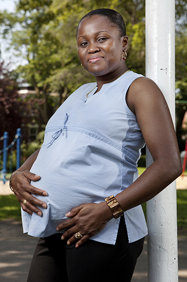 A smiling, expectant African American mother